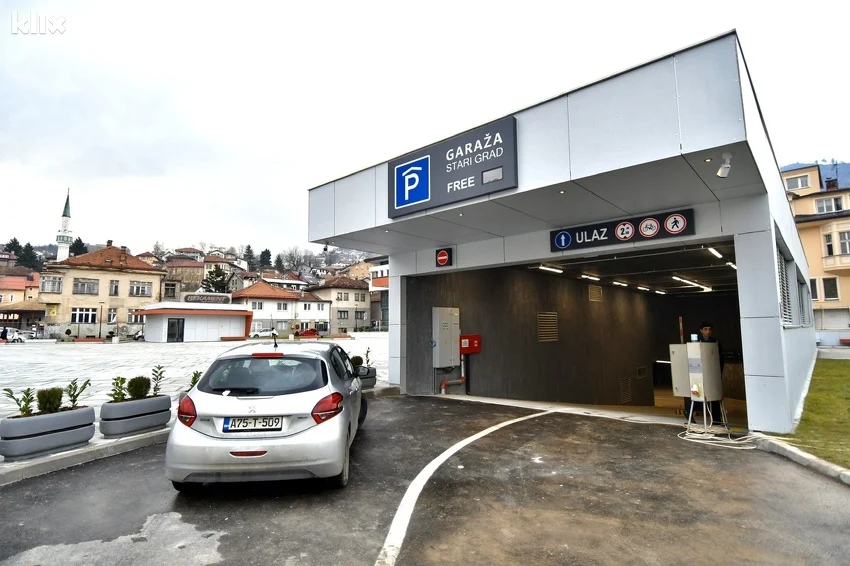 Ulaz u podzemnu garažu Stari Grad u Sarajevu s vidljivim natpisom "Garaža Stari Grad – Free" i automobilom koji ulazi, u pozadini džamija i stambene zgrade starog dijela grada.